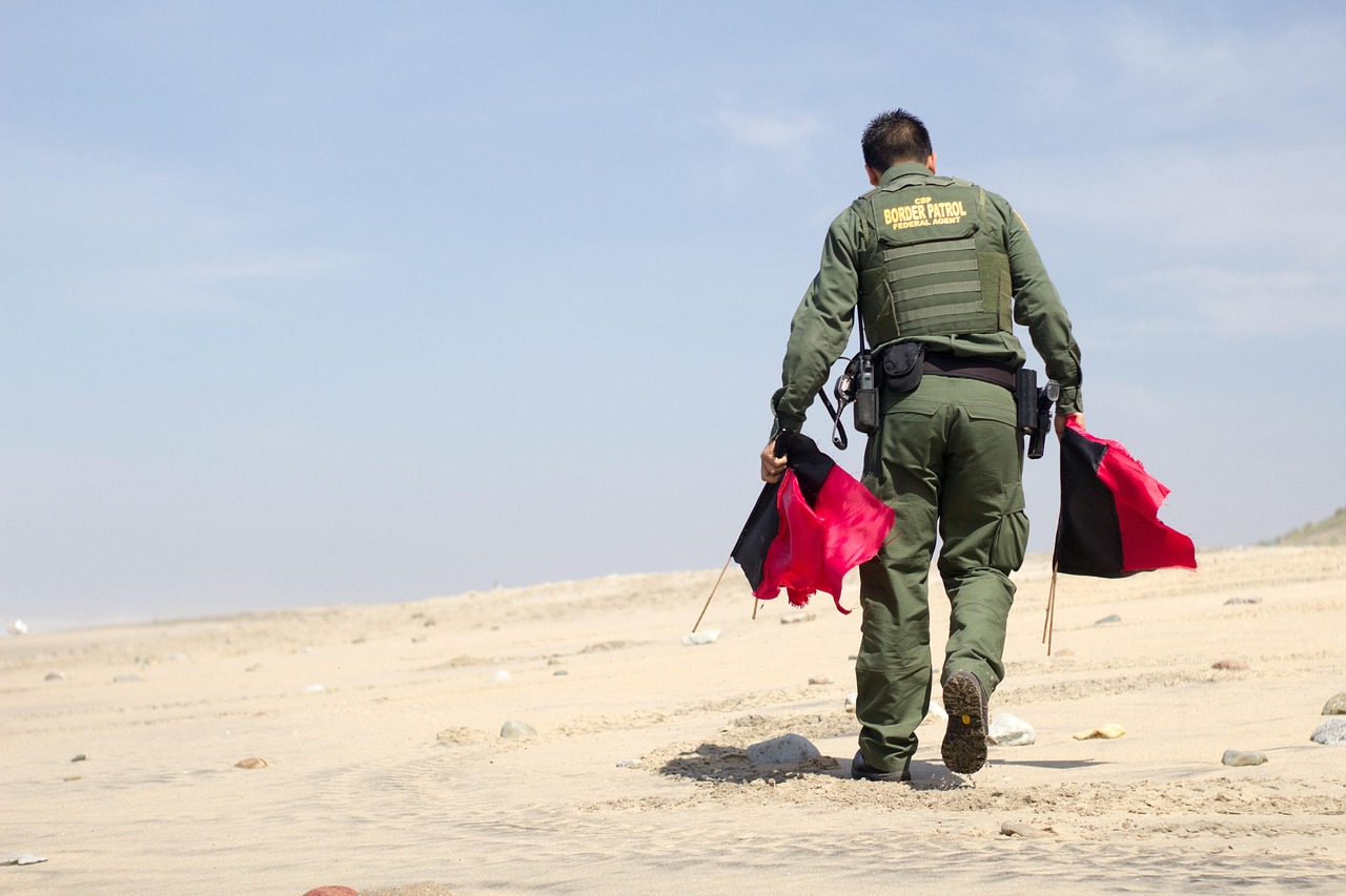Man carrying border patrol flags. Image: Pixabay.