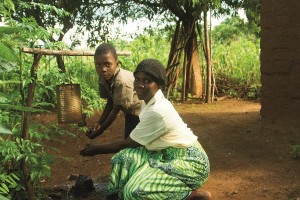 In Malawi, Doney and her son, Junior, use the hand-washing facility they learnt to use through the CADECOM program. Photo: Caritas.