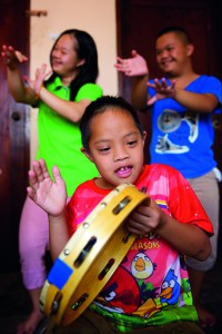 Hum Noy playing the tambourine during a music and dance lesson. Photo: Richard Wainwright/Caritas Australia.