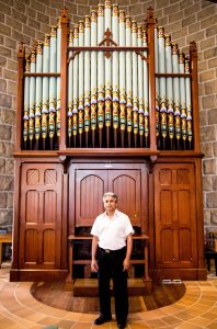 Fr Jolly Chacko MS standing in front of St Finbar's Pipe Organ. Photo: Elizabeth McFarlane.