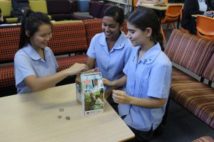 Students from Delany College, Granville, raised more than $2000 for Project Compassion (from left): Year 11 students Hilary Lim, Divashna Kumar and Elisar Salameh busy counting the coins. Photo: Diocese of Parramatta.