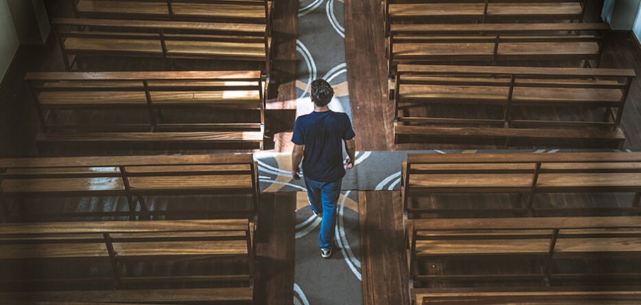 A man walks through an empty church