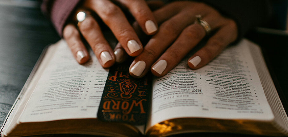 Close up of a woman's hands on top of a bible