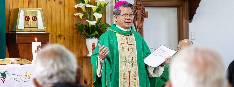 Bishop Vincent Long delivers a homily wearing green vestment